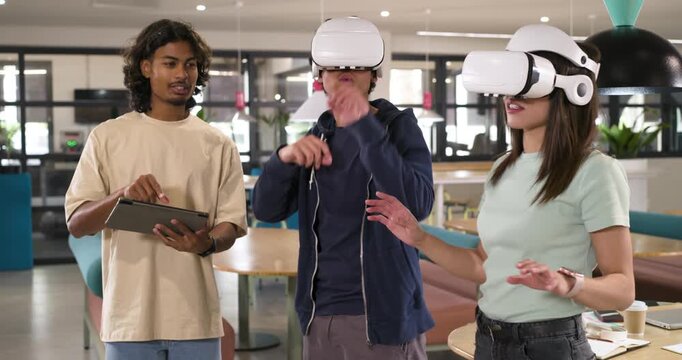 African American coworkers running VR test with white headsets, operator tapping tablet in lounge