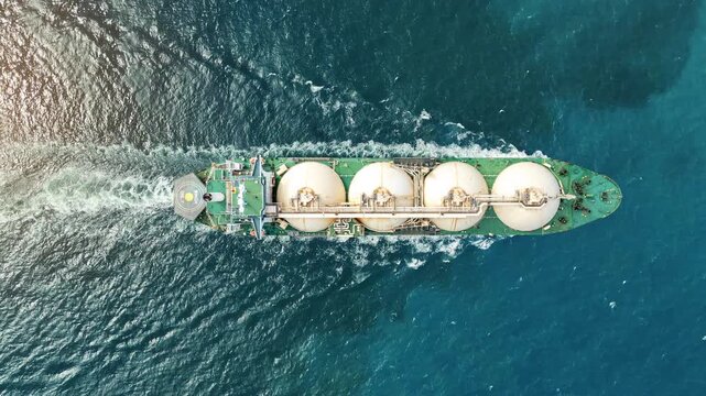 LNG tanker ship sailing in the open ocean. Liquefied Natural Gas carrier vessel with white spherical tanks transporting energy fuel. freight transportation shipping Global gas supply logistics.	
