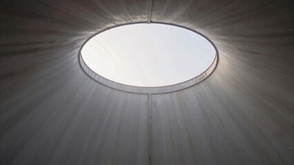 Interior concrete structure circular window center allowing natural light filter illuminate space positioned top casting