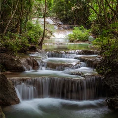 Tuinposter Watervallen Cascading Erawan Falls in Erawan National Park, Thailand. Tropical waterfall flows over rocky terrain. Lush greenery and trees surround the freshwater stream.  © Eugene Ga