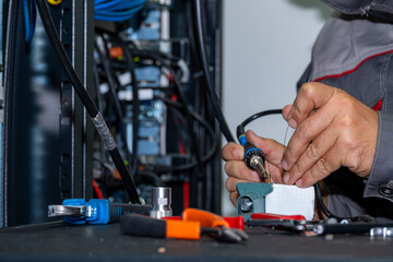 Close up of technician hands soldering RF cable in telecom server room. Professional electronic work, network maintenance, data transmission and modern communication technology concept.