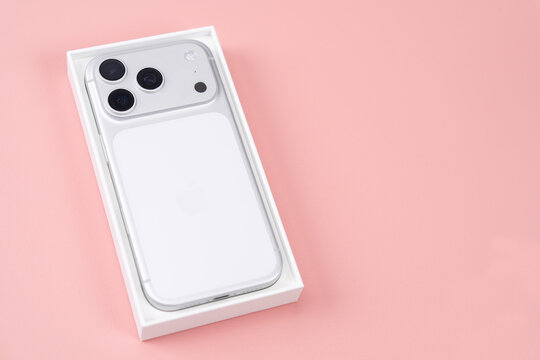White iPhone in box on pink background