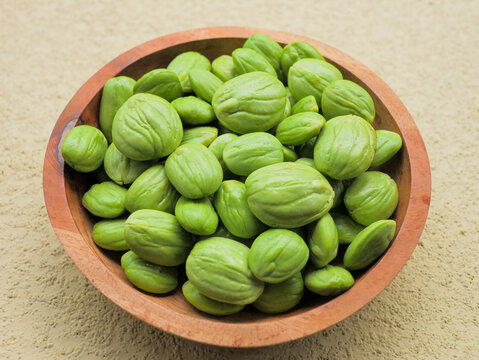 Fresh petai (stink beans) in a wooden bowl. A popular Southeast Asian ingredient known for its bright green color, firm texture, and strong distinctive aroma, commonly used in Indonesian cuisine