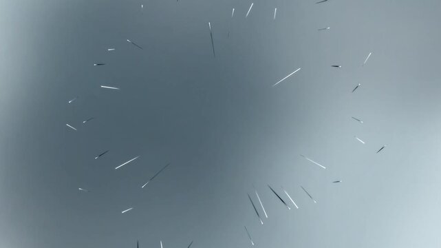 Fractured glass shards scattered on a gray surface from a top viewpoint