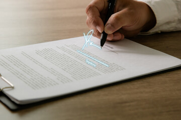 Cropped shot person pen signing a business contract , focus on signature form, secure legal agreement, approval, paperwork, and corporate deal closing.