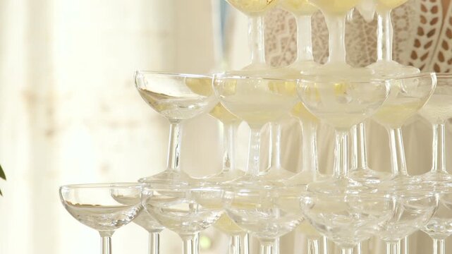 Close up of champagne tower with drink being poured. Handheld