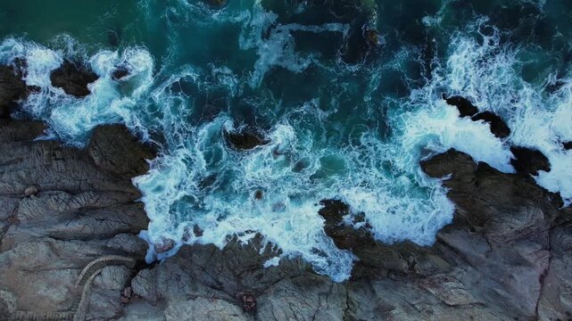 Drone footage capturing waves colliding with rocky coast in Cabo San Lucas