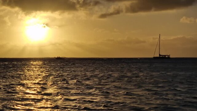 Idyllic Sunset on French Polynesia, Sailboat adn Boat on Sea and Sunlight Reflections