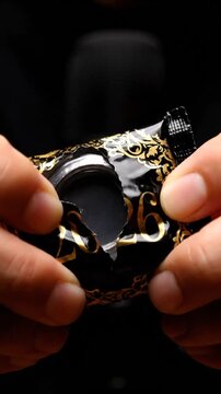Hands holding black package with gold 2026 text