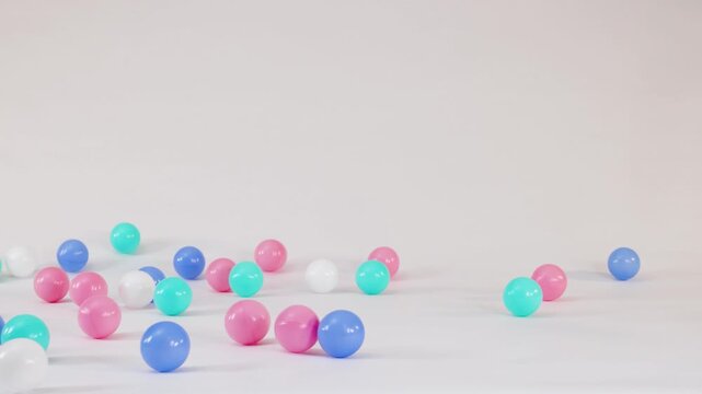 Colorful Plastic Balls Falling and Bouncing on a White Surface