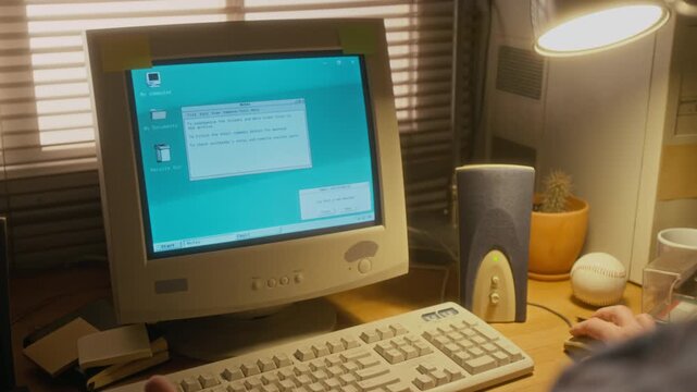 Over-shoulder shot of businessman working on retro computer with blinking CRT monitor, receiving email over internet, notification appearing on screen, then opening to read message