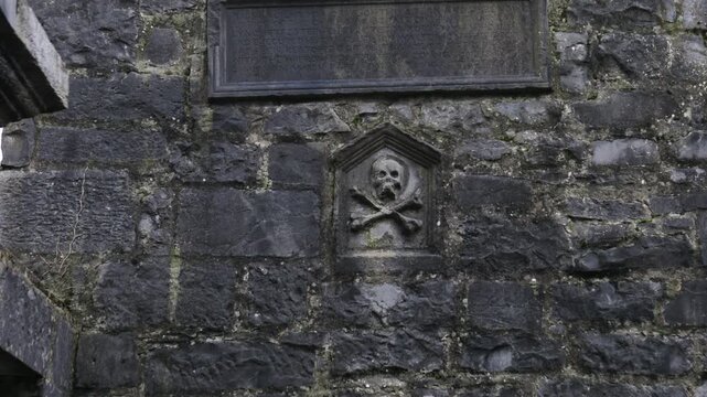 Close up of weathered Gothic scull and crossbones carvings on a historic facade on the Lynch Memorial Window in Galway City