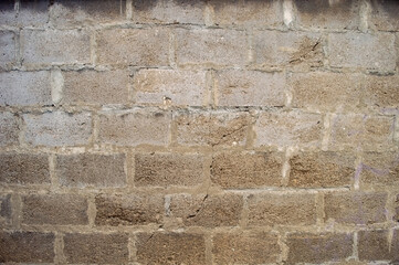 Fototapeta premium A close up of a weathered grey concrete cinder block wall texture, showing its rough surface and grout lines, perfect for architectural or urban design projects