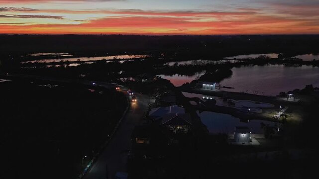Aerial shot of a rural road leading toward the sunset, bordered by expansive rice fields in Tondol, Pangasinan.