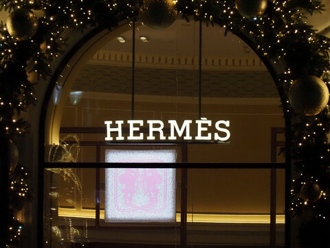 Close up of the illuminated Hermes logo on a boutique window in Warsaw at night