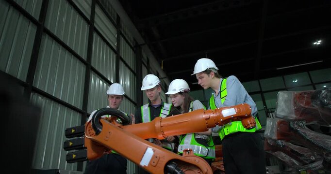 Engineering supervisor mentors trainee in robotics environment, emphasizing the importance of leadership, communication, and continuous education in managing complex machinery and technical processes
