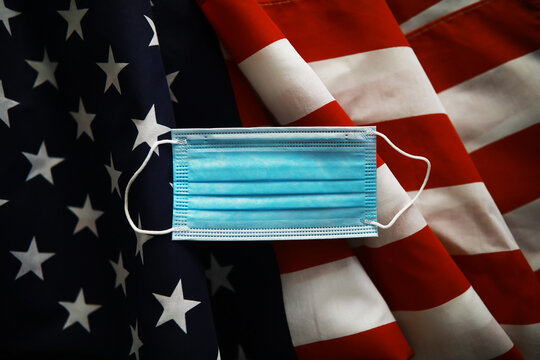 American health care system. USA flag background. Medical mask and restrictions.