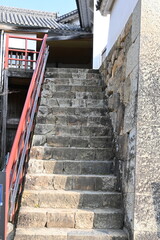 城郭の歴史を刻む石段：赤い手すりと古い石垣のコントラスト