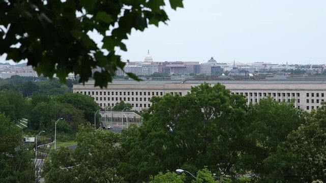Pentagon complex in Arlington, Virginia near Washington, D.C., viewed across trees with the D.C. skyline in the background on an overcast day