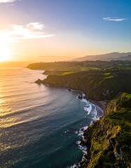 Coastal aerial view capturing the golden sunset and rugged coastline