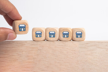Franchise business, Businessman hand choose wooden blog with franchise marketing icons Store. Franchise business concept.