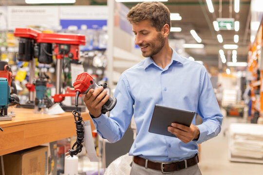 Warehouse worker scan goods in inventory in a hardware store and check stock product on digital tablet