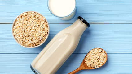 Milk and oats sit on a blue wooden table for a simple breakfast setup