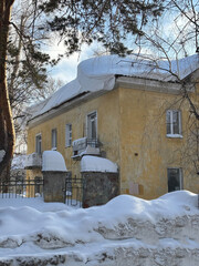 Winter urban landscape, Siberia, Novosibirsk, roofs of houses are covered with a thick layer of snow.