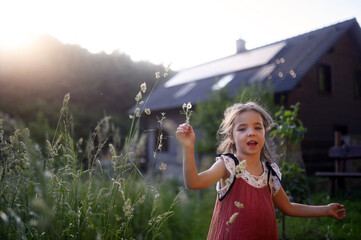 Girl in front of house with solar panels on roof. © Halfpoint