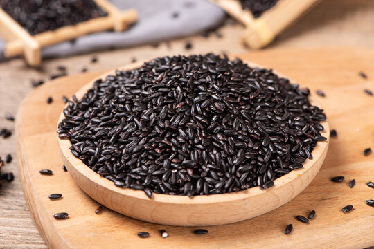 Raw black rice grains on table.