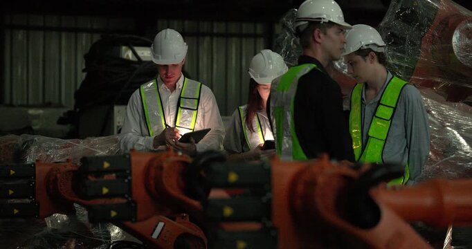 Engineering supervisor mentors trainee in robotics environment, emphasizing the importance of leadership, communication, and continuous education in managing complex machinery and technical processes
