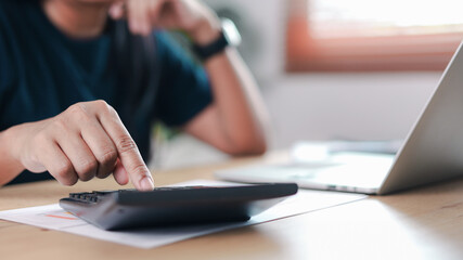 Fototapeta premium Business finance professional calculating budget using calculator and laptop on office desk. Concept of accounting, financial analysis, tax planning, corporate work, investment management,