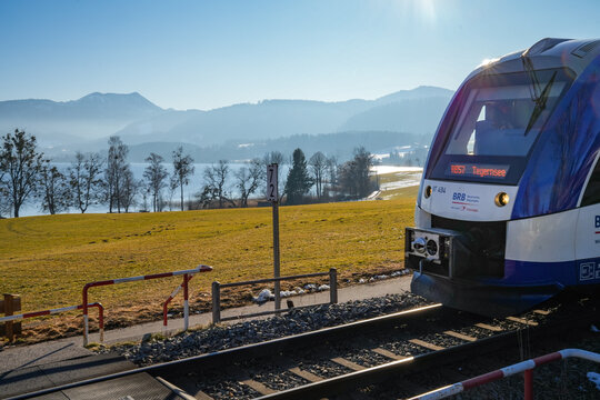 A train operated by Bayerische Regiobahn (BRB) at a railroad crossing near Gmund at Lake Tegernsee in Bavaria. A popular destination for day trips, easily accessible by train