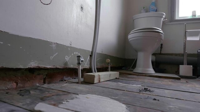Bathroom renovation; tracking shot across stripped back room during daytime.