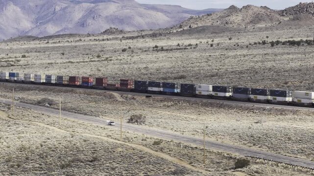 Aerial of shipping containers on freight line train in Arizona desert near Kingman