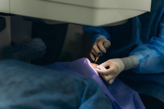 Ophthalmologist administering an eye injection to a patient