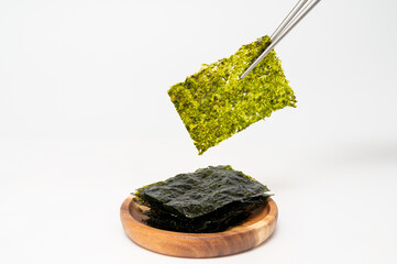 흰 배경에 젓가락으로 잡고 있는 한국 전통 김