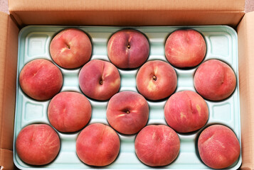 段ボール箱の中にきれいに並んだ新鮮な桃