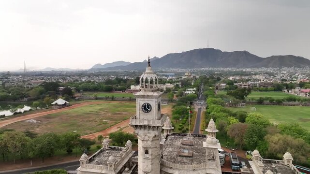 Heritage building clock tower surrounded by garden and Aravalli hills, Mayo College, Drone shot