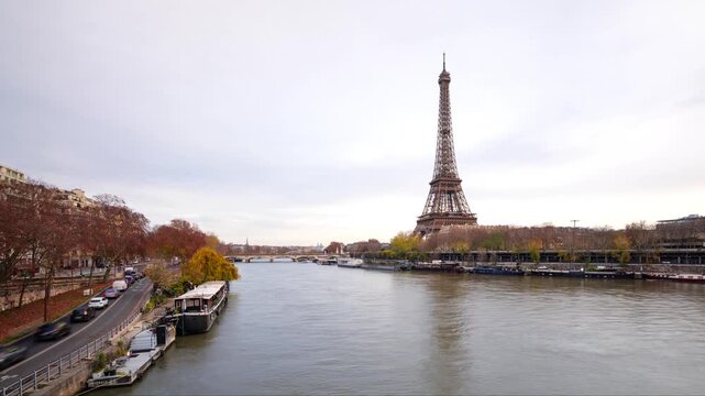 Hyperlapse of Eiffel Tower in Paris on the river Seine in winter with traffic and falling leaves