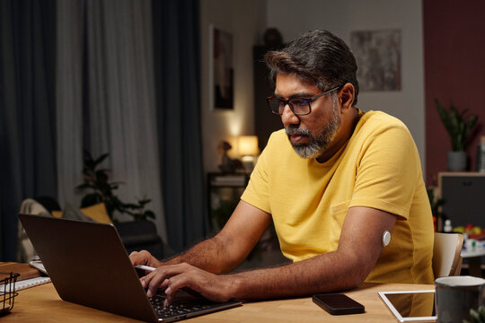 Man working on laptop at home office with insulin patch visible