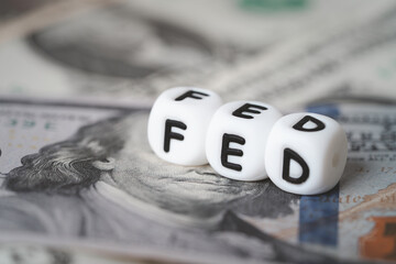 Federal Reserve concept with FED letter cubes on US dollar banknotes representing monetary policy, interest rate decision, inflation control, central banking, financial market and US economy.