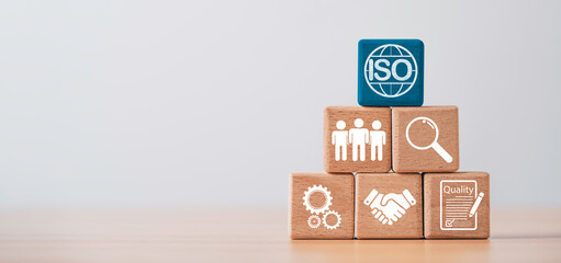 ISO quality management system concept with wooden blocks icons representing quality assurance, compliance, inspection, teamwork, process control and business standards on clean background.