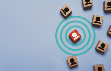 Target customer concept with a human icon inside concentric circles surrounded by people symbols representing audience targeting, customer segmentation and customer relation management or CRM.