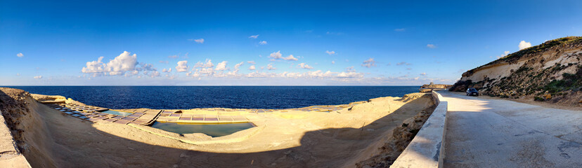 Panoramic view of the historic salt pans on the coast near Zebbug on Gozo, Malta, overlooking the Mediterranean Sea