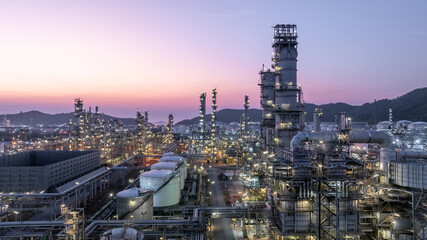 Obraz premium Aerial view oil and gas petrochemical storage tank with oil and gas refinery plant at twilight, Global business power and energy petrochemical industry, Oil and gas refinery petrochemical industrial.