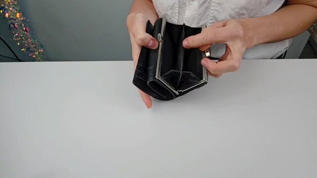 Young woman opening empty wallet at home &ndash; cashless lifestyle, digital payments trend, tactile material, everyday modern life