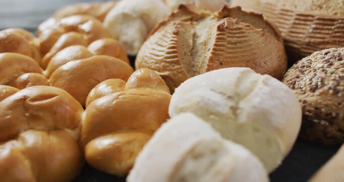 Video of rolls and bread on wooden worktop seeing from above