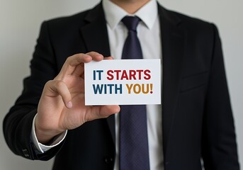 Obraz premium A businessman in a suit holding a card with a motivational message