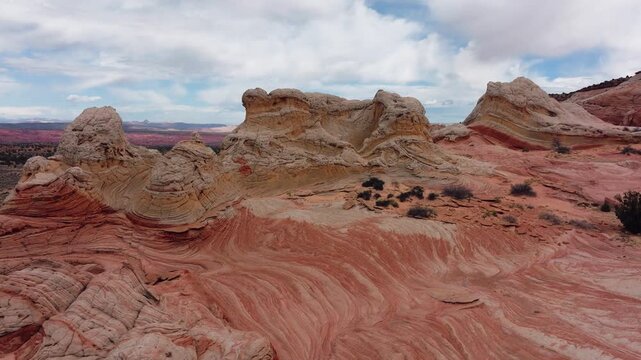 Aerial view of the undulating, layered sandstone formations of The Wave, displaying a symphony of red, orange, and cream hues, Page, Arizona, United States.